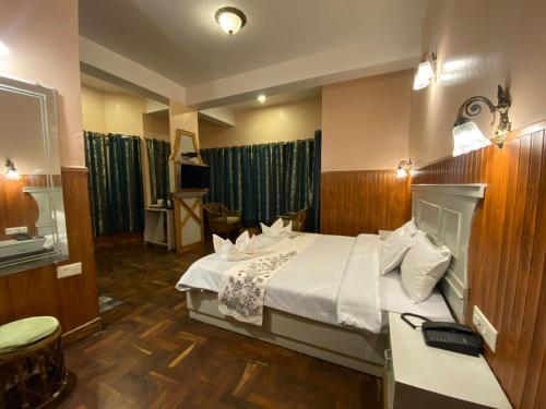 una camera d'albergo con letto e TV di Lamahatta Residency a Darjeeling