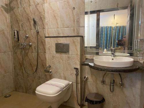 e bagno con servizi igienici, lavandino e doccia. di Lamahatta Residency a Darjeeling
