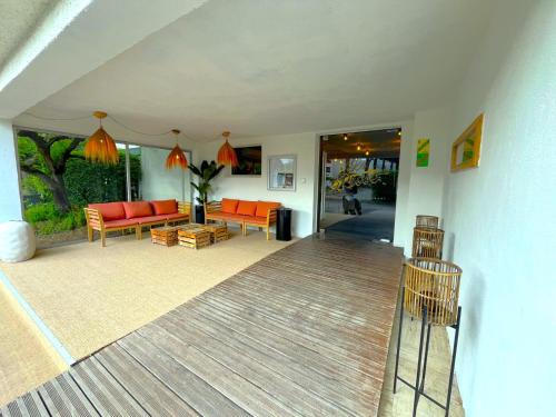 a living room with orange furniture and a porch at Le Prose Hôtel in La Grande Motte