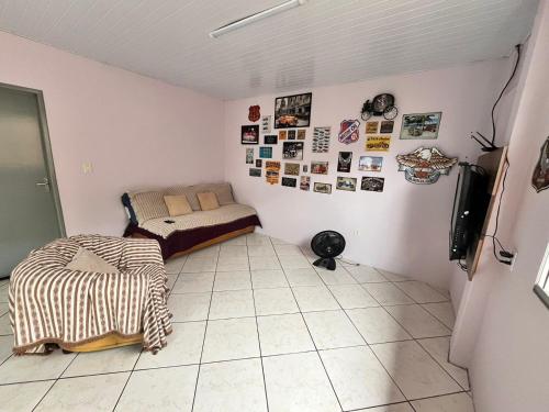 a small room with a bed and a tiled floor at Casa espaçosa e aconchegante Jphouse in São José