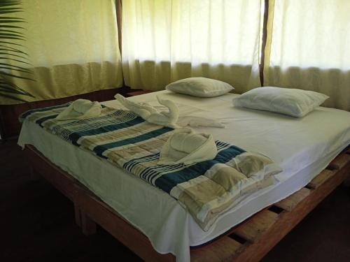 ein Bett mit Handtüchern und Kissen darauf in der Unterkunft Amazon Jungle Reps in Nauta