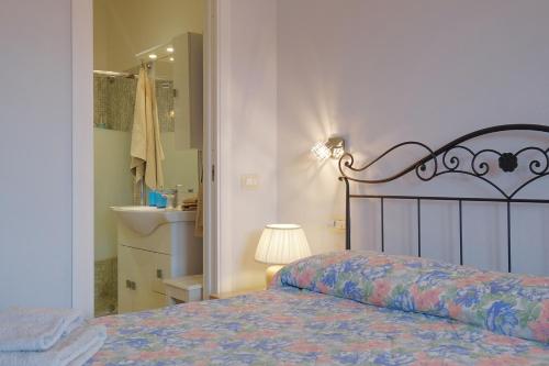 a bedroom with a bed and a bathroom with a sink at CASA AZZURRA - BLUE HOUSE in Teulada