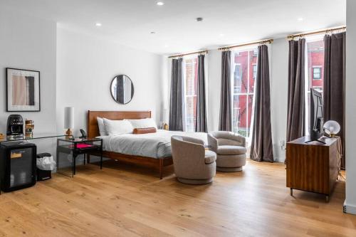 a white bedroom with a bed and a chair at DTWN Historic Hotel, West Market Square View, King Bed, Room # 200 in Bangor