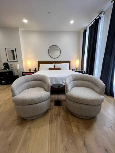a bedroom with two chairs and a bed at DTWN Historic Hotel, West Market Square View, King Bed, Room # 200 in Bangor