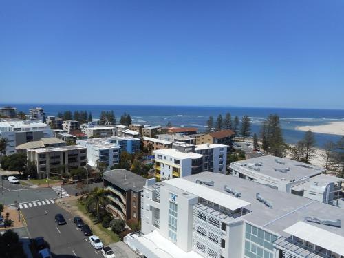 an aerial view of a city with buildings and the ocean at The Waterford Prestige Apartments in Caloundra