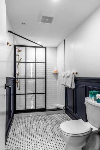 a bathroom with a white toilet and a shower at DTWN Historic Hotel, West Market Square View, King Bed, Room # 200 in Bangor