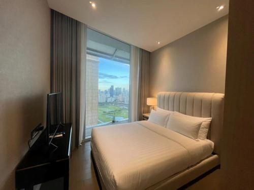 ein Hotelzimmer mit einem Bett und einem großen Fenster in der Unterkunft Chit Lom, Siam BTS, Perfect Best Location High Floor Sleeps 4 81sqm in Bangkok