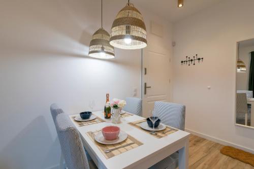 a dining room with a table with two chairs and two lights at Na Skraju Lasu e-apart in Jastrzębia Góra