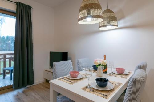 a dining room with a table with two chairs and a dining room at Na Skraju Lasu e-apart in Jastrzębia Góra
