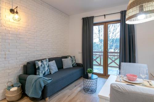 a living room with a couch and a brick wall at Na Skraju Lasu e-apart in Jastrzębia Góra