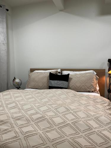 a bedroom with a large bed with a bedspread at Cozy Haven! in Edmonton