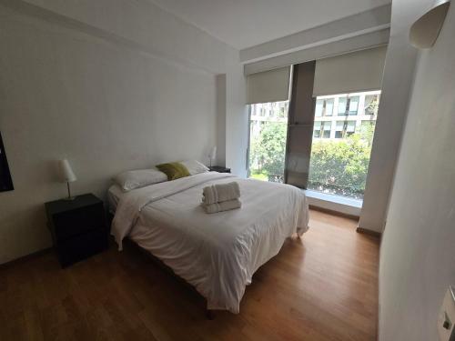 1 dormitorio con 1 cama con sábanas blancas y ventana en Amazing Location Behind Hilton Hotel, en Ciudad de México