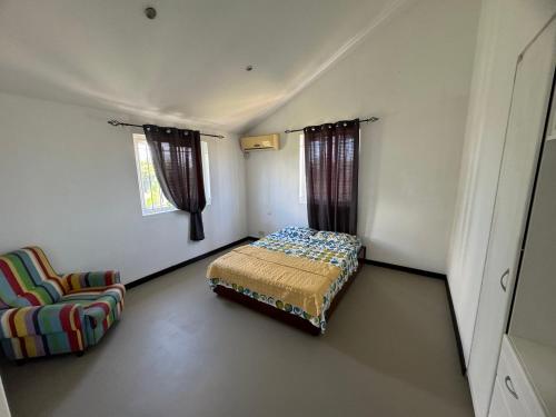 1 dormitorio pequeño con 1 cama y 1 silla en Villa Piefraper, en Grand Gaube