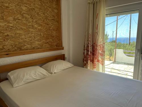 a bed with two pillows in a room with a window at Studios Crete in Ferma