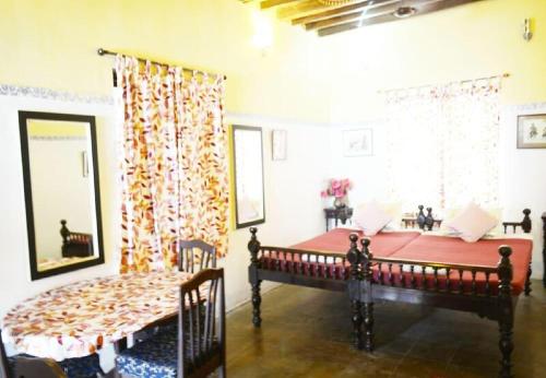 Schlafzimmer mit einem Bett und einem Fenster in der Unterkunft LA VILLA CREOLE in Puducherry