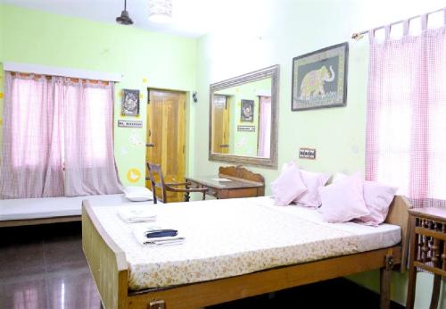 um quarto com uma cama grande e lençóis brancos em LA VILLA CREOLE em Pondicherry
