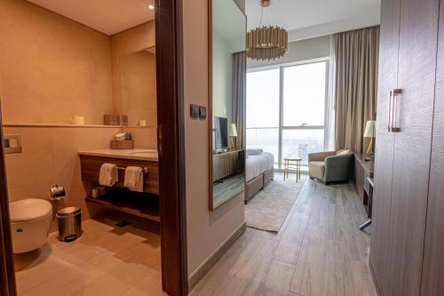 a hotel room with a bathroom with a toilet and a television at Avani Plus Palm View Dubai Suites in Dubai