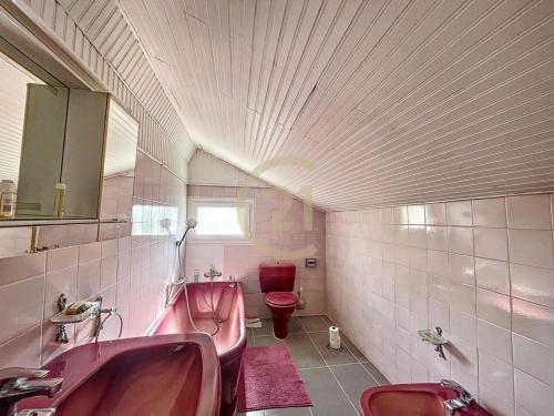 La salle de bains est pourvue de 2 lavabos roses et de toilettes. dans l'établissement JO Family House, à Nanterre