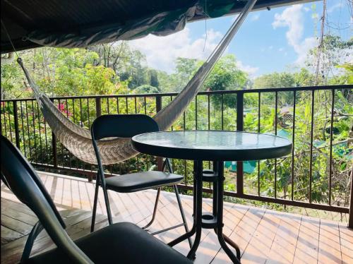 a hammock and a table and chair on a deck at Casa Patricia in Uvita