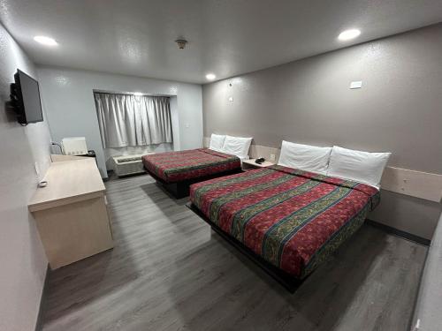 um quarto de hotel com duas camas e uma televisão de ecrã plano em Motel 6 Idabel, OK em Idabel