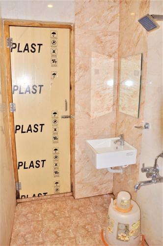 a bathroom with a sink and a door with the words blast blast place at Srirathna Temple View Inn in Thanjāvūr