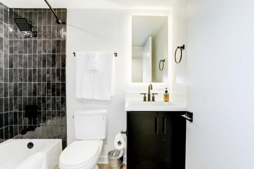 uma casa de banho com um WC, um lavatório e uma banheira em 2BR Comfort Apartment in Prime Location em Arlington