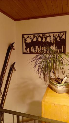 a plant on a table with a picture on the wall at The Raven B&B in Ayer
