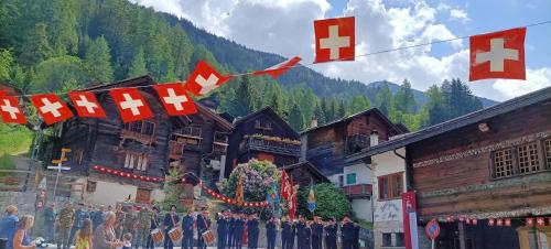 a group of people standing in front of buildings with flags at The Raven B&B in Ayer