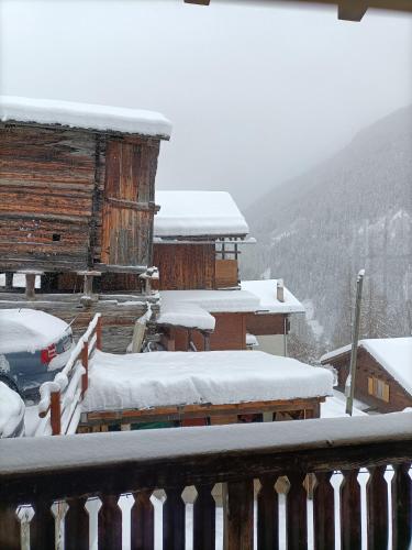 a snow covered cabin with a car parked in front at The Raven B&B in Ayer