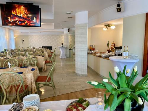 a restaurant with tables and chairs and a fireplace at Hotel Calisia in Kalisz