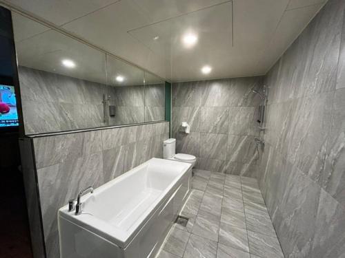 a bathroom with a tub and a toilet and a television at Bulgwang 3S Hotel in Seoul