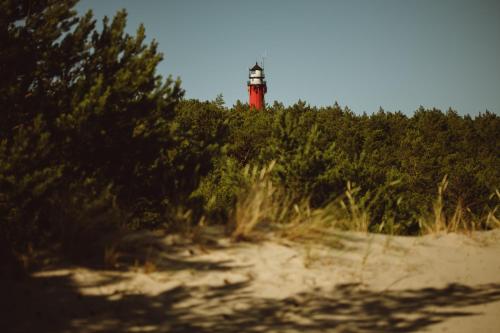 a red lighthouse sitting on top of a beach at Boho Sfera in Kopalino