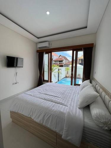 a bedroom with a bed with a view of a pool at Akara Villa Jimbaran in Jimbaran