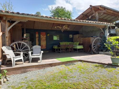 une terrasse en bois avec des chaises et une table dans l'établissement Location en pré montagne, à Saleich