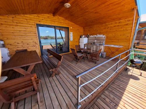 a cabin with a wooden deck with a table and chairs at Ada Bojana kucica Una in Ulcinj
