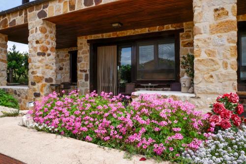 a garden with pink flowers in front of a building at Hotel Valdelinares (Soria) in Valdelinares