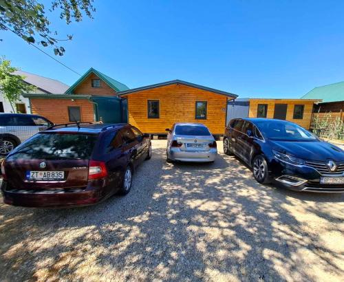 two cars parked in a parking lot in front of a house at Ada Bojana kucica Una in Ulcinj