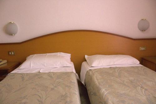 two beds sitting next to each other in a room at Hotel Nord Ovest in Monte Grimano Terme