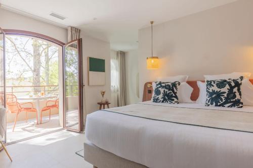 a bedroom with a large bed and a balcony at La Bastide Bourrelly - Mathias Dandine in Cabriès