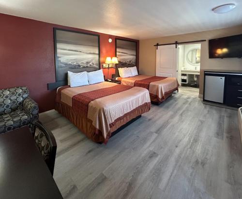 a hotel room with two beds and a flat screen tv at Motel 6 Pasadena, CA Old Town Pasadena Area in Pasadena