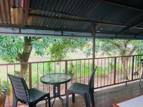 a table and chairs on a balcony with a tree at Casa Patricia in Uvita