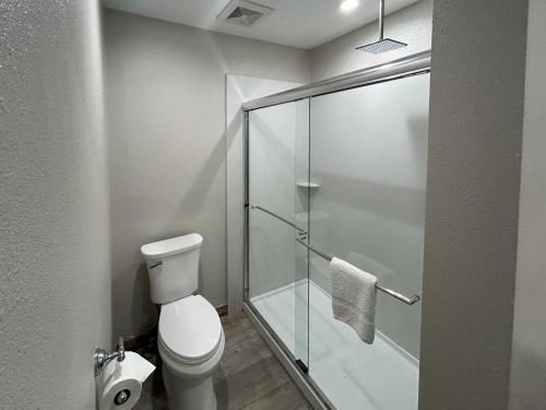 a bathroom with a toilet and a glass shower stall at Motel 6 Pasadena, CA Old Town Pasadena Area in Pasadena