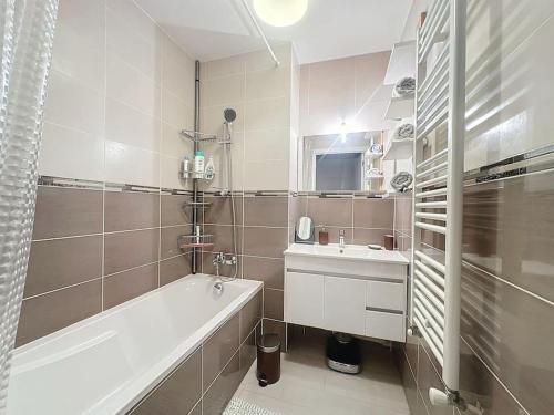 ein Badezimmer mit einer Badewanne und einem Waschbecken in der Unterkunft Cozy apartment near Paris Disney - 6 min from train station in Villiers-sur-Marne