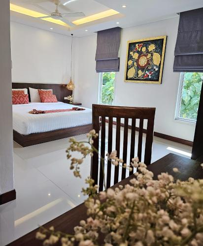 a bedroom with a bed and a table with a chair at JJ Queen Villa and Spa Kohyaonoi in Ko Yao Noi