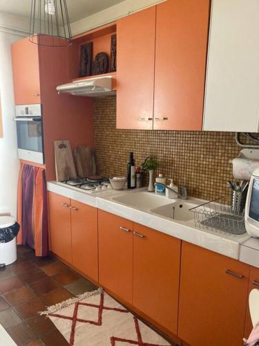 une cuisine avec des armoires orange et un évier dans l'établissement Magnifique appartement face mer, à Canet