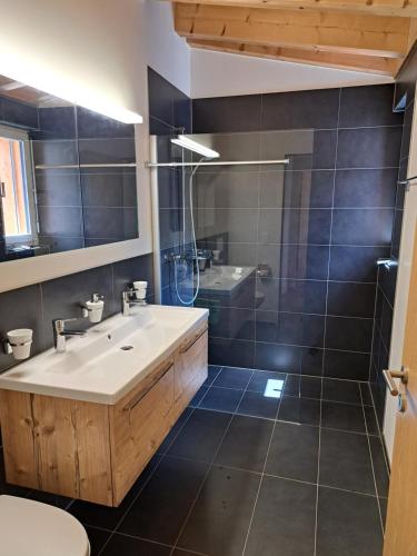a bathroom with a sink and a shower at Chalet-Stil privat Zimmer 1-4 in Engelberg