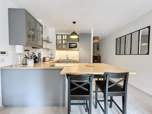 une cuisine avec deux chaises sur un îlot de cuisine dans l'établissement Cozy apartment near Paris Disney - 6 min from train station, à Villiers-sur-Marne