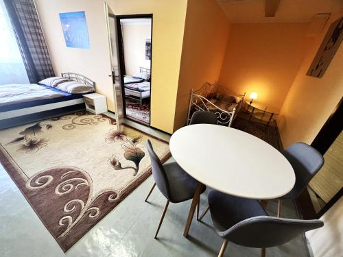 a room with a table and chairs and a bedroom at Hotel Penzion Rohožník in Prague