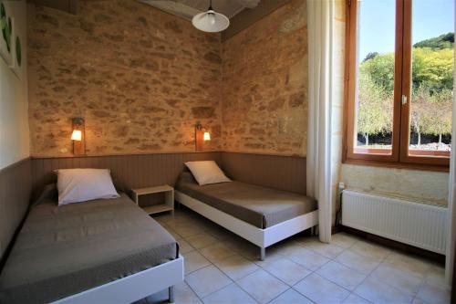 une chambre avec deux lits et une fenêtre dans l'établissement Gîtes la Palombière La Mélonie, à Bézenac