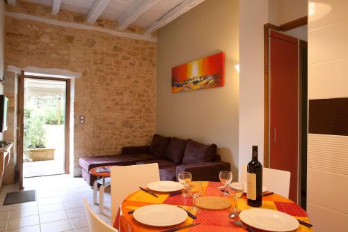 un salon avec une table avec une bouteille de vin dans l'établissement Gîtes la Palombière La Mélonie, à Bézenac